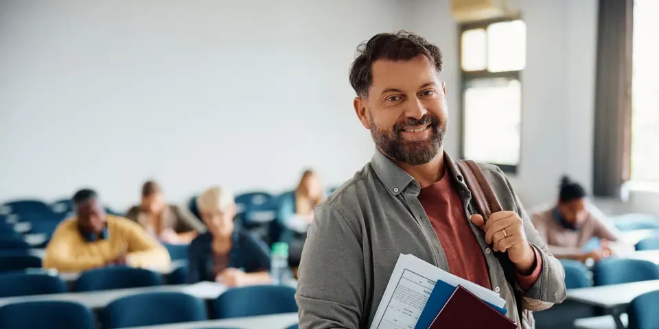 Happy mature man attending adult education training course and looking at camera.